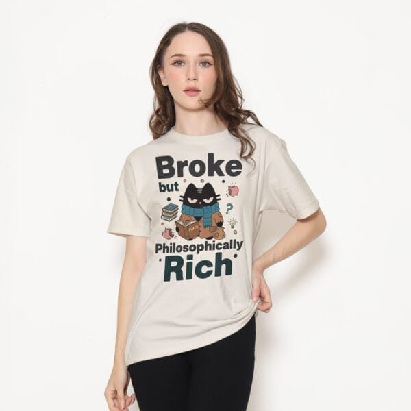 Female model wearing a funny philosophy beige t-shirt with the 'Broke but Philosophically Rich' graphic.