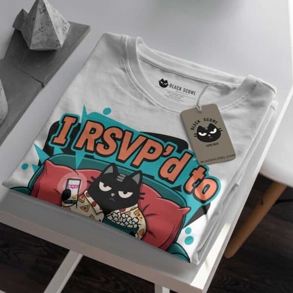 rsvp-couch-black-scowl-folded-tshirt-tag Folded white t-shirt showing the 'I RSVP'd to My Couch' graphic and Black Scowl brand tag.