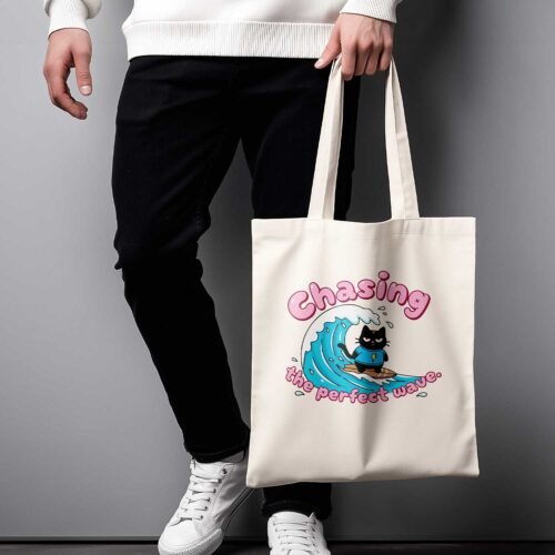 Black Scowl tote bag in oyster color featuring a grumpy cat surfing illustration and ironic summer text.