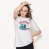Model wearing white t-shirt with sarcastic surfing cat design, trendy urban outfit for introverts and anti-social summer fashion.