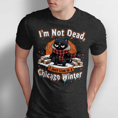 Black Scowl graphic t-shirt featuring a frozen black cat bundled in a winter coat and scarf. Text reads I'm Not Dead I Just Live in a Chicago Winter.