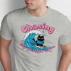 Close up of grumpy black cat wearing blue shirt with lightning bolt surfing on a wave, high quality DTG print detail for urban sarcasm clothing.