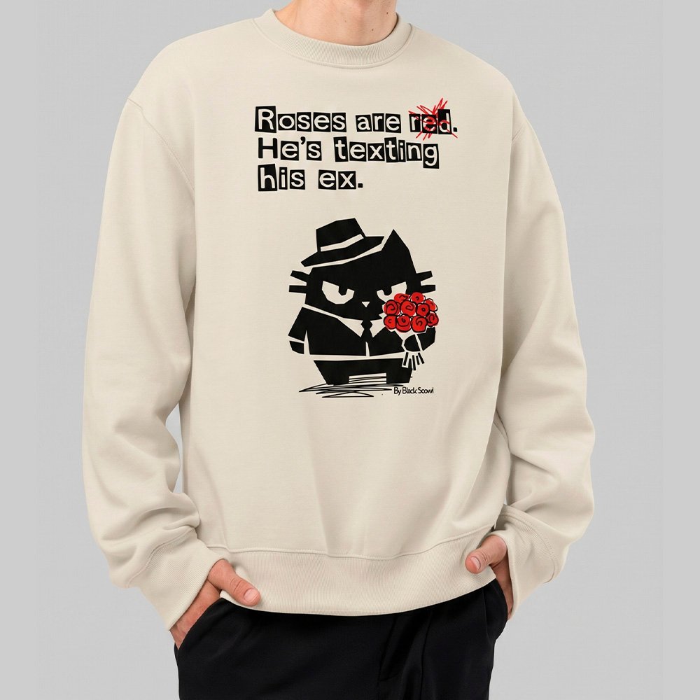 Male model wearing Black Scowl heavyweight oversize sweatshirt with a sarcastic quote about a toxic ex and a cynical cat holding red roses.