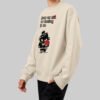 Side angle view of a model showcasing the relaxed fit of the Black Scowl modern urban clothing sweatshirt in beige, featuring dark humor streetwear aesthetics.