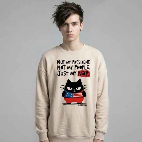 Male model wearing Black Scowl heavyweight oversize sweatshirt with a sarcastic political quote Not My President and a cynical cat graphic.