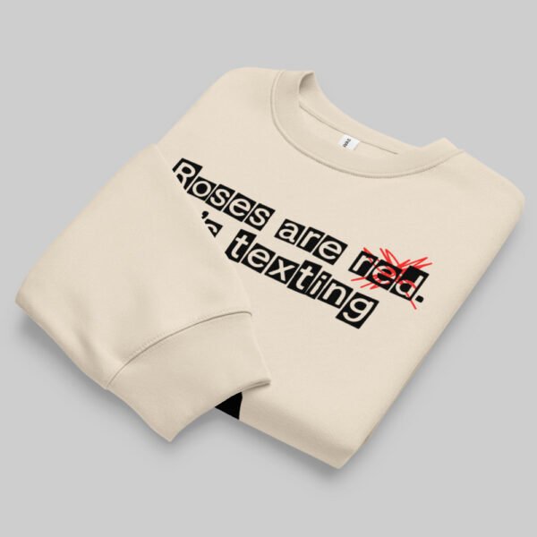 Folded flat lay of the Black Scowl sarcastic crewneck sweater in beige, displaying the premium print of the edgy "texting his ex" urban fashion graphic.