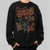 Front view of a male model wearing a Black Scowl black heavyweight crewneck featuring a vintage-style "Born to Do Nothing" graphic with an avant-garde cat silhouette.