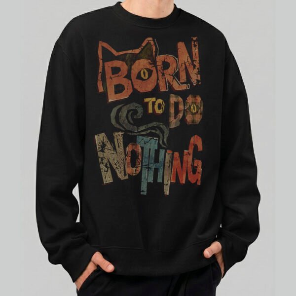 Front view of a male model wearing a Black Scowl black heavyweight crewneck featuring a vintage-style "Born to Do Nothing" graphic with an avant-garde cat silhouette.