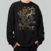 Front view of a male model wearing a Black Scowl black heavyweight crewneck featuring a distressed "Same Shit New Day" urban graphic and a cynical cat character