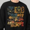 Close-up of a Black Scowl black heavyweight crewneck featuring a distressed, colorful graphic that reads "Zero Energy Full Attitude" with an edgy cat design.