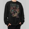 Black Scowl black crewneck sweatshirt featuring an edgy graphic of a sarcastic cat playing drums. Front view of the urban streetwear on a male model.
