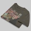 Professional flat-lay shot of a folded Black Scowl charcoal oversized graphic t-shirt highlighting the premium fabric texture and interior neck branding.