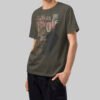 Side angle view of a model in a Black Scowl charcoal-toned streetwear t-shirt showcasing the premium structured oversized fit and dropped shoulder design.