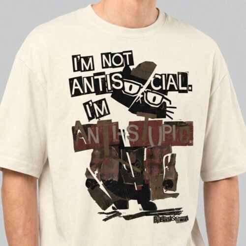 Close-up detail of the Black Scowl cream heavyweight tee showing the distressed typography and the sophisticated grumpy cat design.