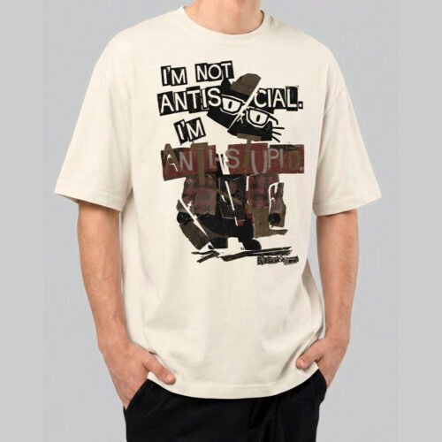 Front view of a male model wearing a Black Scowl cream oversized t-shirt with a sarcastic "I'm Not Antisocial I'm Anti-Stupid" feline graphic.