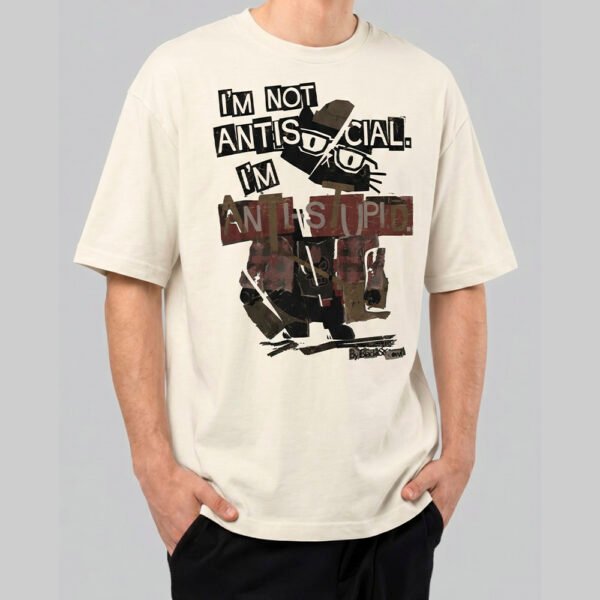 Front view of a male model wearing a Black Scowl cream oversized t-shirt with a sarcastic "I'm Not Antisocial I'm Anti-Stupid" feline graphic.
