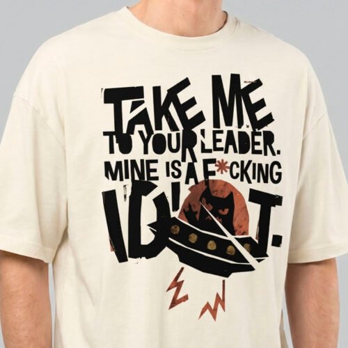 Close-up zoom of the high-quality distressed print on a Black Scowl cream oversized t-shirt highlighting the bold typography and sarcastic UFO cat design.