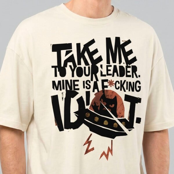 Close-up zoom of the high-quality distressed print on a Black Scowl cream oversized t-shirt highlighting the bold typography and sarcastic UFO cat design.