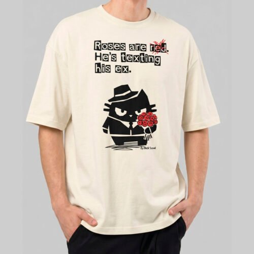 Front view of a male model wearing a Black Scowl cream oversized t-shirt featuring a sarcastic "Roses are red, He's texting his ex" graphic with a tuxedo cat character.