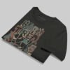 A professionally folded Black Scowl washed black graphic tee on a gray background, showcasing the durable heavyweight fabric and vibrant abstract art.