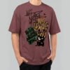 Front view of a male model wearing a Black Scowl maroon heavyweight t-shirt featuring a cynical "My Mistake Was Loving You" graphic with an angry black cat.