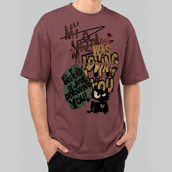 Front view of a male model wearing a Black Scowl maroon heavyweight t-shirt featuring a cynical "My Mistake Was Loving You" graphic with an angry black cat.