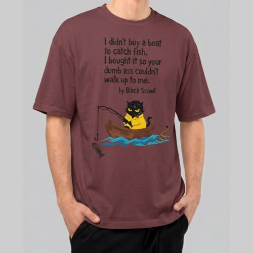 Front view of a male model wearing a Black Scowl maroon oversized t-shirt featuring a sarcastic "I didn't buy a boat to catch fish" graphic with a cat in a rowboat.