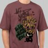 Close-up zoom of the distressed typography and cynical cat illustration on a Black Scowl maroon oversized t-shirt highlighting the high-quality print detail.
