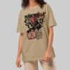 A female model wearing the Black Scowl sand-colored graphic wear tee with a relaxed avant-garde silhouette and a dark humor punk-inspired design.