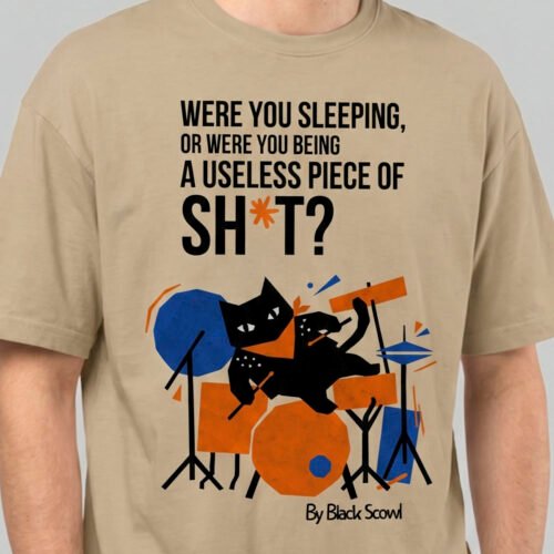 Close-up detail of the Black Scowl sand heavyweight tee showing the high-quality print of the abstract cat drummer and bold cynical typography.