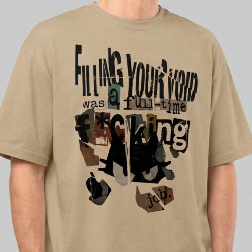 Close-up zoom of the distressed collage print on a Black Scowl sand oversized t-shirt highlighting the premium fabric texture and edgy typography.