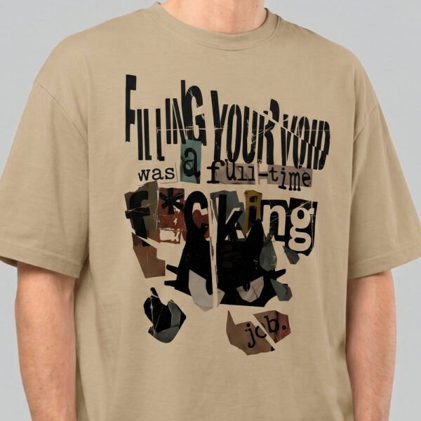 Close-up zoom of the distressed collage print on a Black Scowl sand oversized t-shirt highlighting the premium fabric texture and edgy typography.