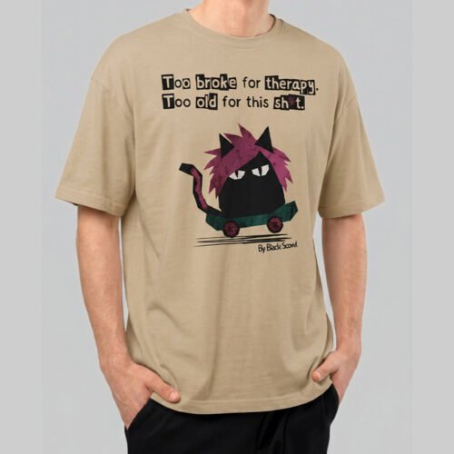 Front view of a male model wearing a Black Scowl sand oversized t-shirt with a sarcastic cat on a skateboard graphic and "Too broke for therapy" text.