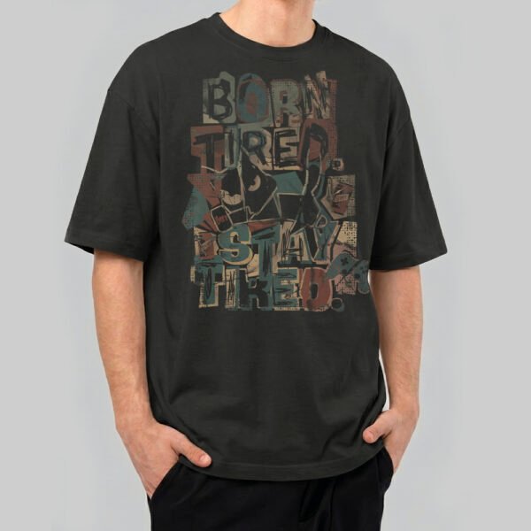 Front view of a male model wearing a Black Scowl washed black oversized t-shirt featuring a colorful "Born Tired Stay Tired" abstract graffiti design.