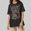 A female model wearing the Black Scowl black heavyweight graphic tee with a modern avant-garde fit and cynical urban design.