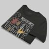 Professional flat-lay shot of a folded Black Scowl black oversized graphic t-shirt showing the interior neck label and high-quality 220g cotton texture.