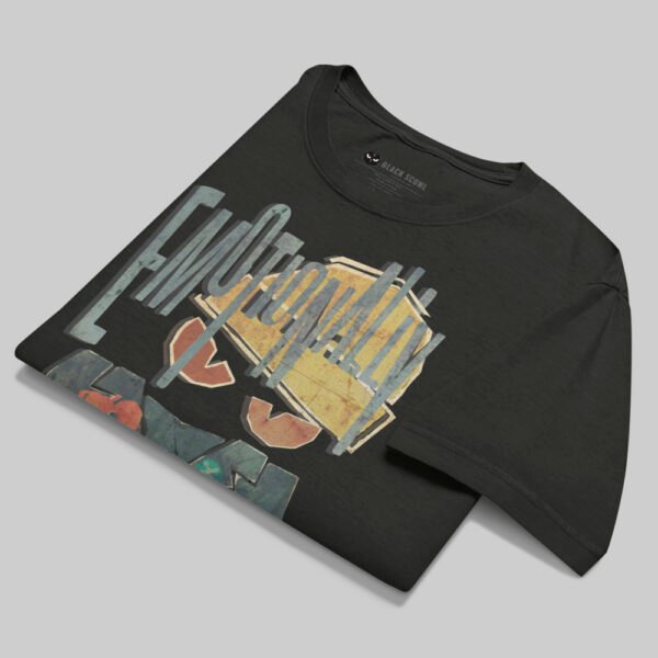 Professional flat-lay shot of a folded Black Scowl black oversized graphic t-shirt showing the interior neck label and high-quality 220g cotton texture.