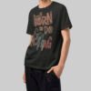 Side angle view of a model in a Black Scowl black streetwear t-shirt showcasing the structured heavyweight fabric and relaxed boxy silhouette.